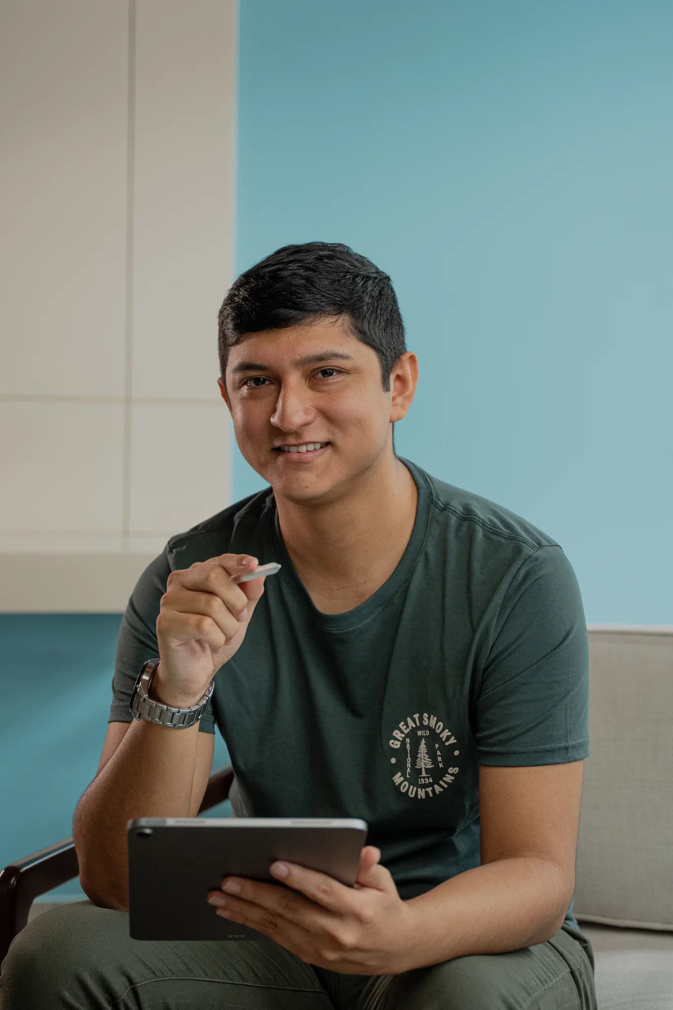 Geoffrey Vásquez sentado con una tableta y un lápiz óptico.
