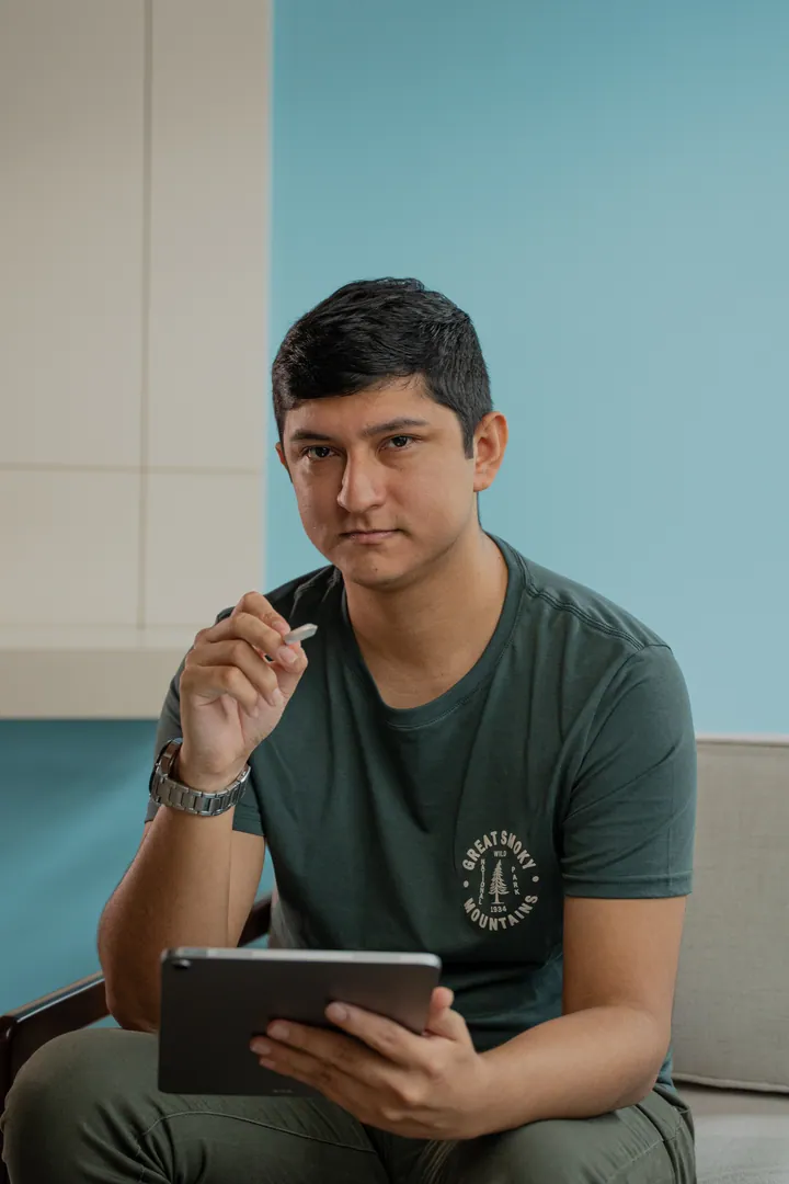 Geoffrey Vásquez sentado en su espacio de trabajo